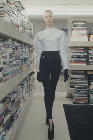 Model wears studded leggings with a white blouse in Alaïa Fall 2023 runway show