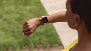 Fitbit Versa 3 review: person checking their health stats by looking at the Versa 3 on their wrist