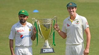 Captains Babar Azam of Pakistan and Pat Cummins of Australia holding a trophy ahead of cricket Test match