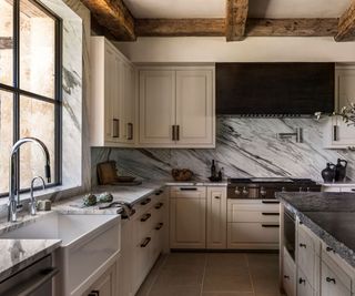Kitchen with sink cooker hood and warm white cabinetry