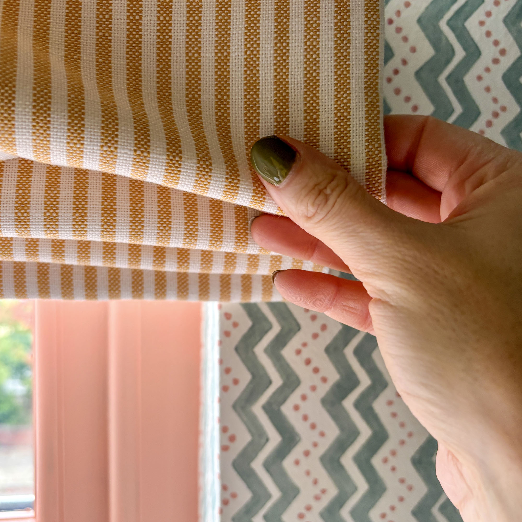 striped window blind held out by a hand