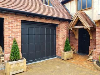 A mock tudor house with a panelled electric garage door 