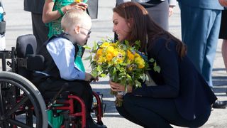 Kate Middleton accepting flowers from a young boy