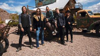 Buckcherry posing by a barn and an old truck