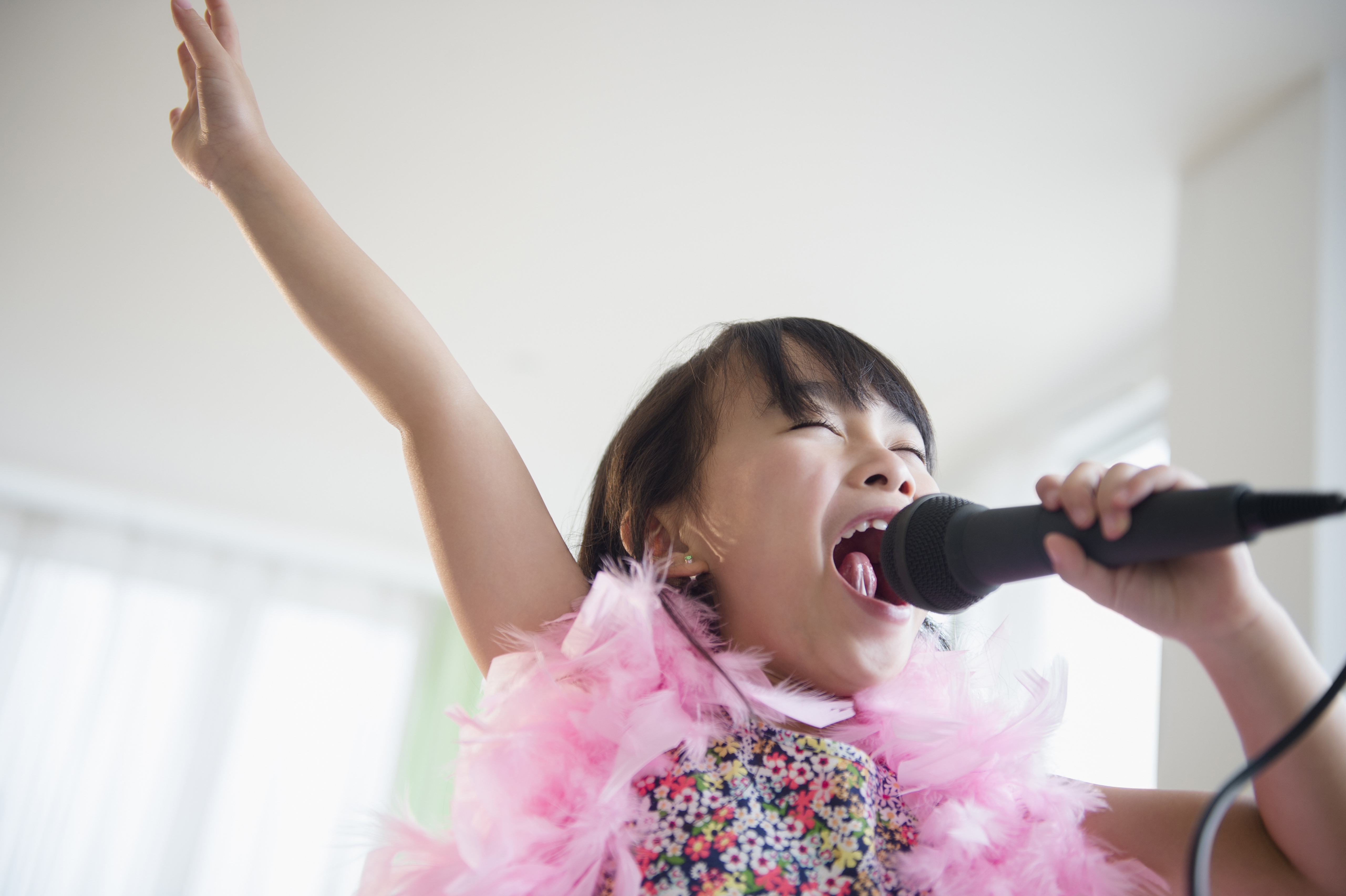 Girl singing karaoke in her living room during lockdown