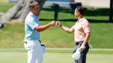 Bryson DeChambeau of the United States and Rory McIlroy of Northern Ireland bump fists after finishing on the 18th green during the final round of the Charles Schwab Challenge on June 14, 2020 at Colonial Country Club in Fort Worth, Texas. 