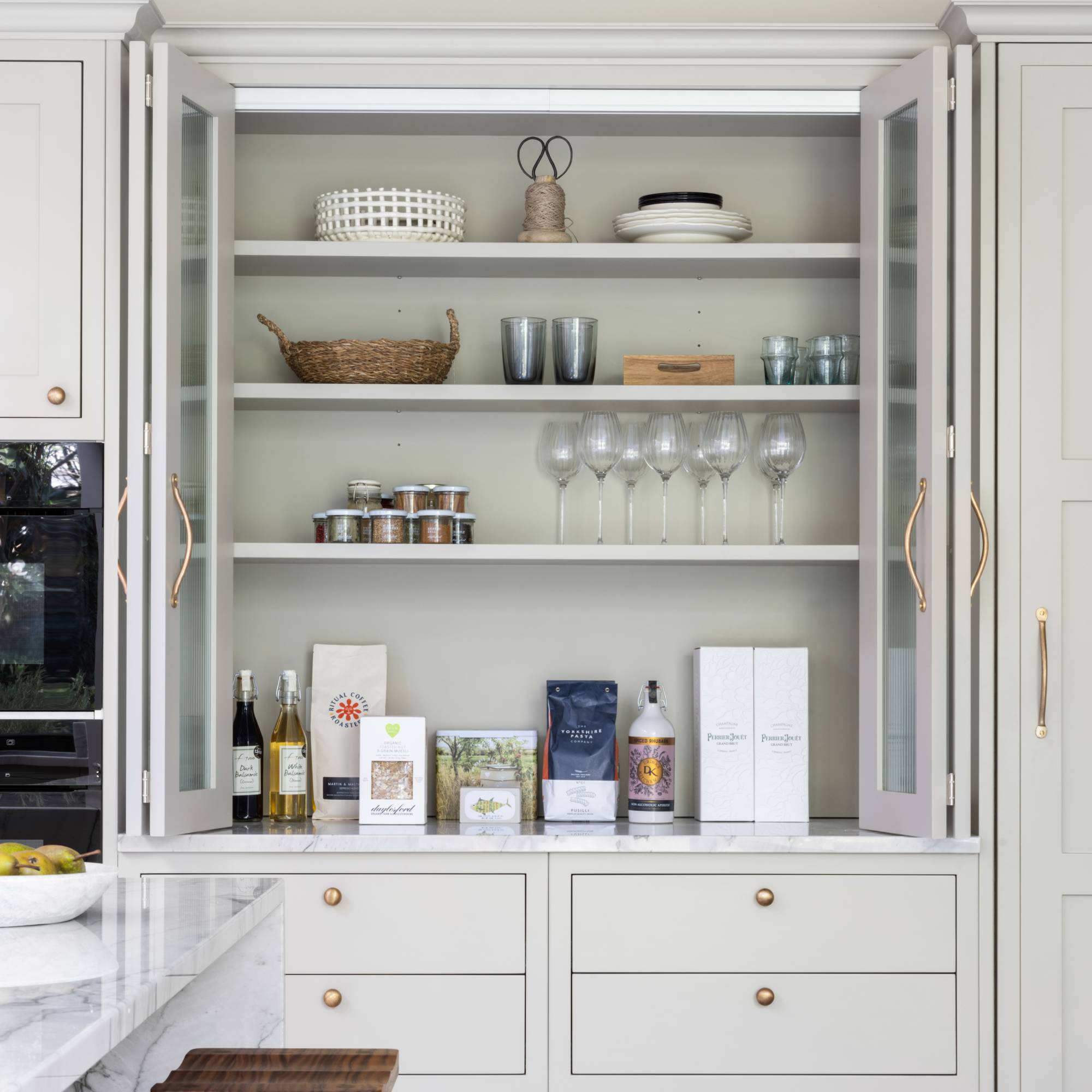 off white kitchen units with glass fronted pantry style cabinet