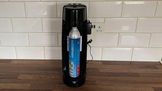 The rear view of the Sodastream Spirit One Touch on a kitchen countertop, with the gas cylinder exposed