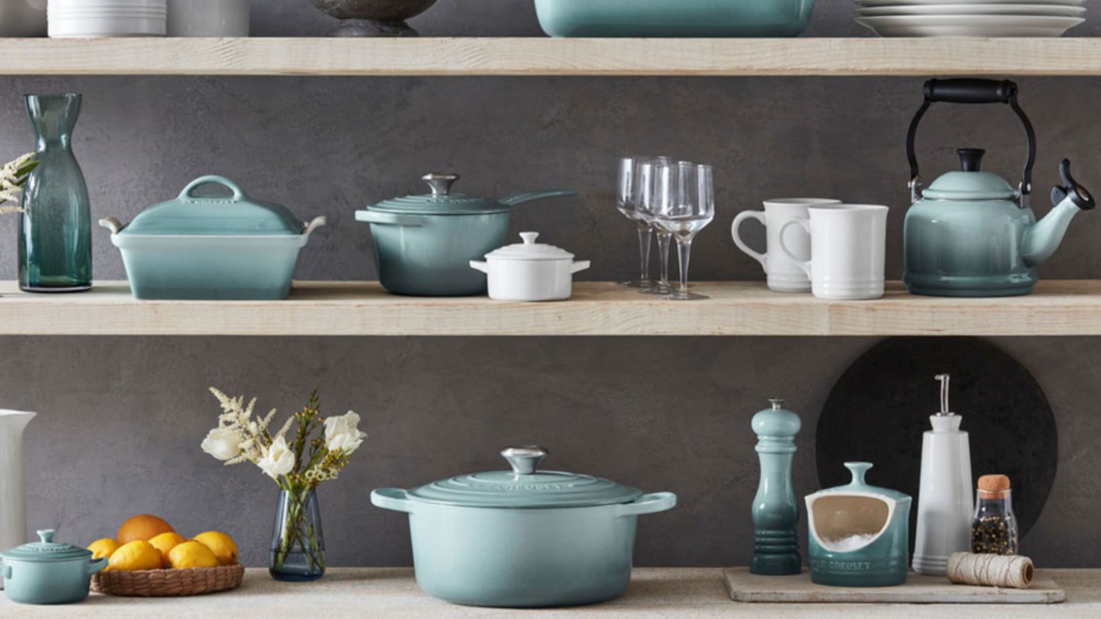 Le Creuset shelves filled with &#039;sea salt&#039; color dishes and white tableware 