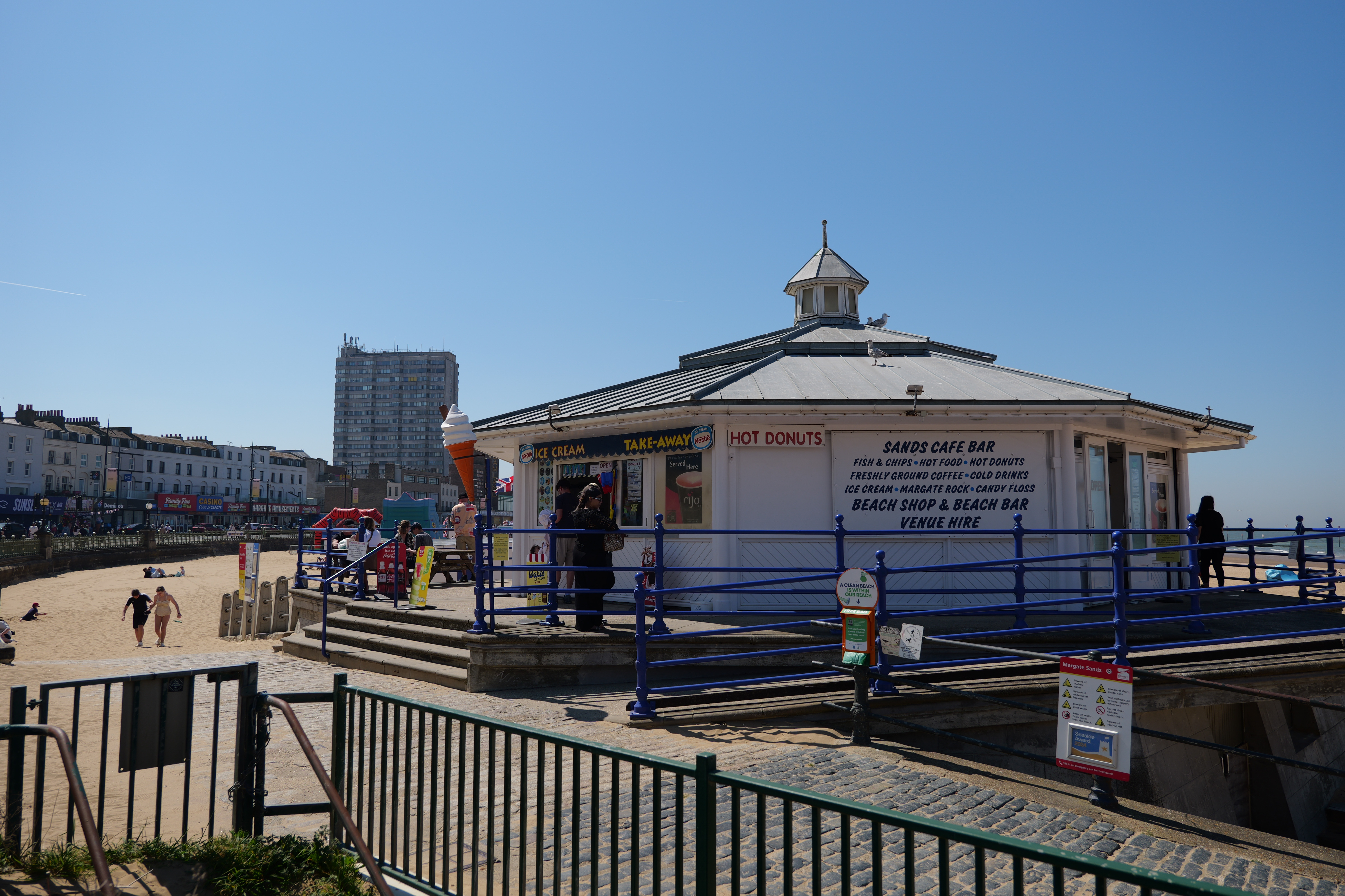 A hut selling hotdogs and ice creams on a beach