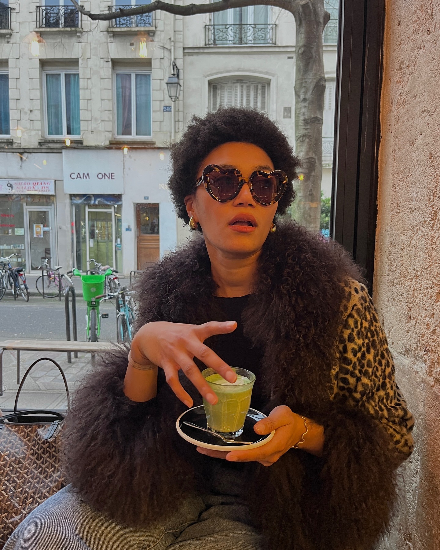 Influencer @lenafarl wears a fur-trimmed jacket with grey jeans and love-heart sunglasses.