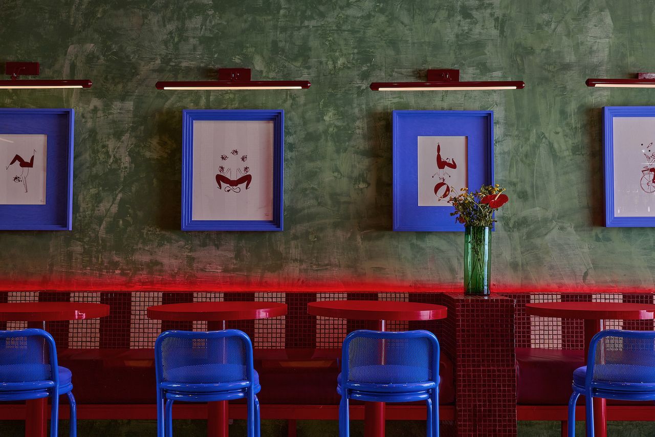 Bright red tables with azure blue chairs and pistachio green walls