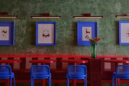 Bright red tables with azure blue chairs and pistachio green walls