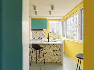 A kitchen with yellow walls and green cabinets