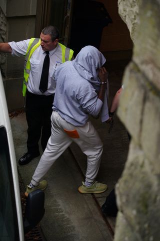 A man, believed to be co-defendant Louis Saha Matturie, gets out of a prison van at Chester Crown Court