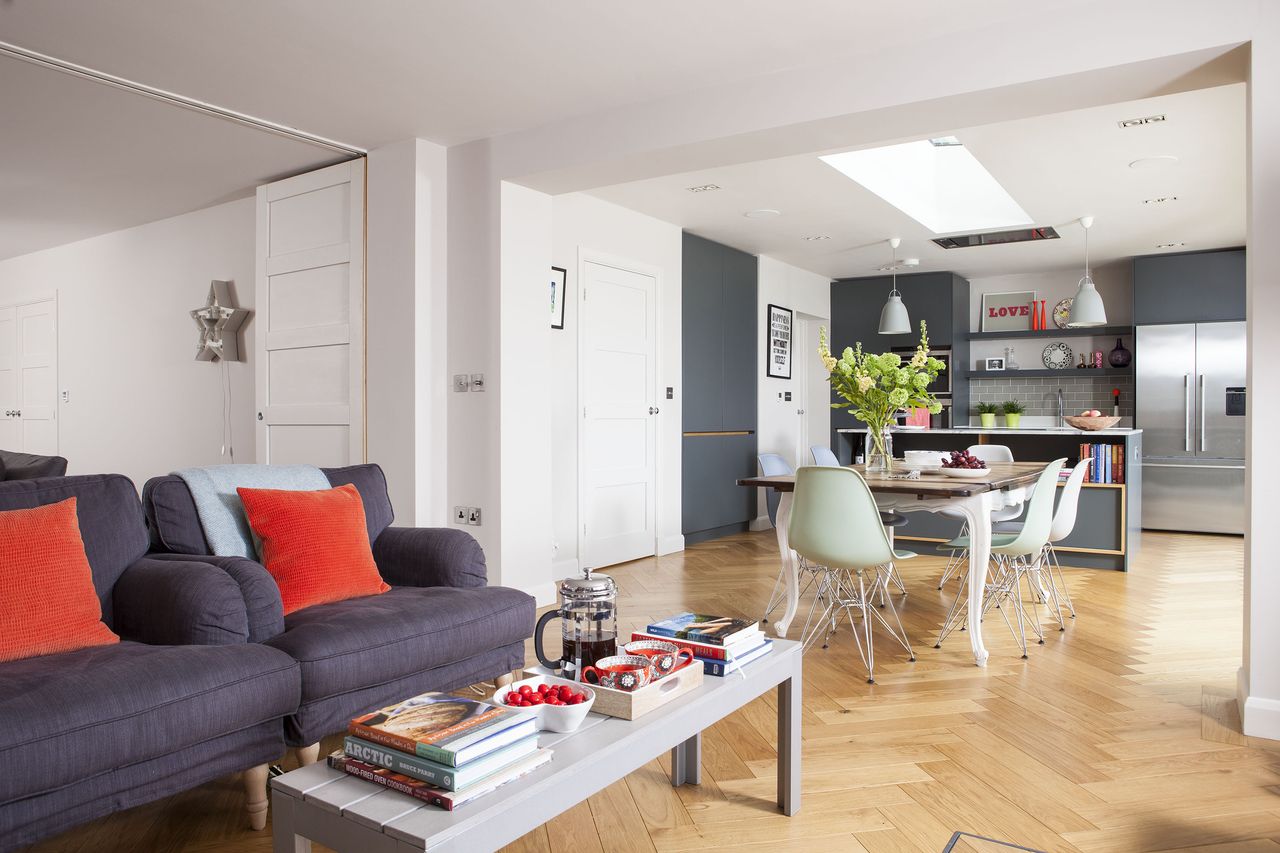 open plan modern kitchen-diner and living area with pastel chairs and wooden flooring