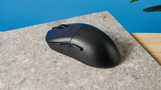 A black Lemokey G1 wireless gaming mouse sitting on a marble slab