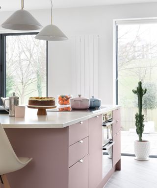 A bright kitchen with a pink kitchen island