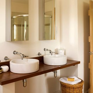 washroom with white wall wash basin on wooden counter and wall mirror