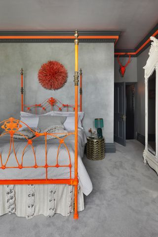 Bedroom with neon painted bed and neon accents on the grey walls