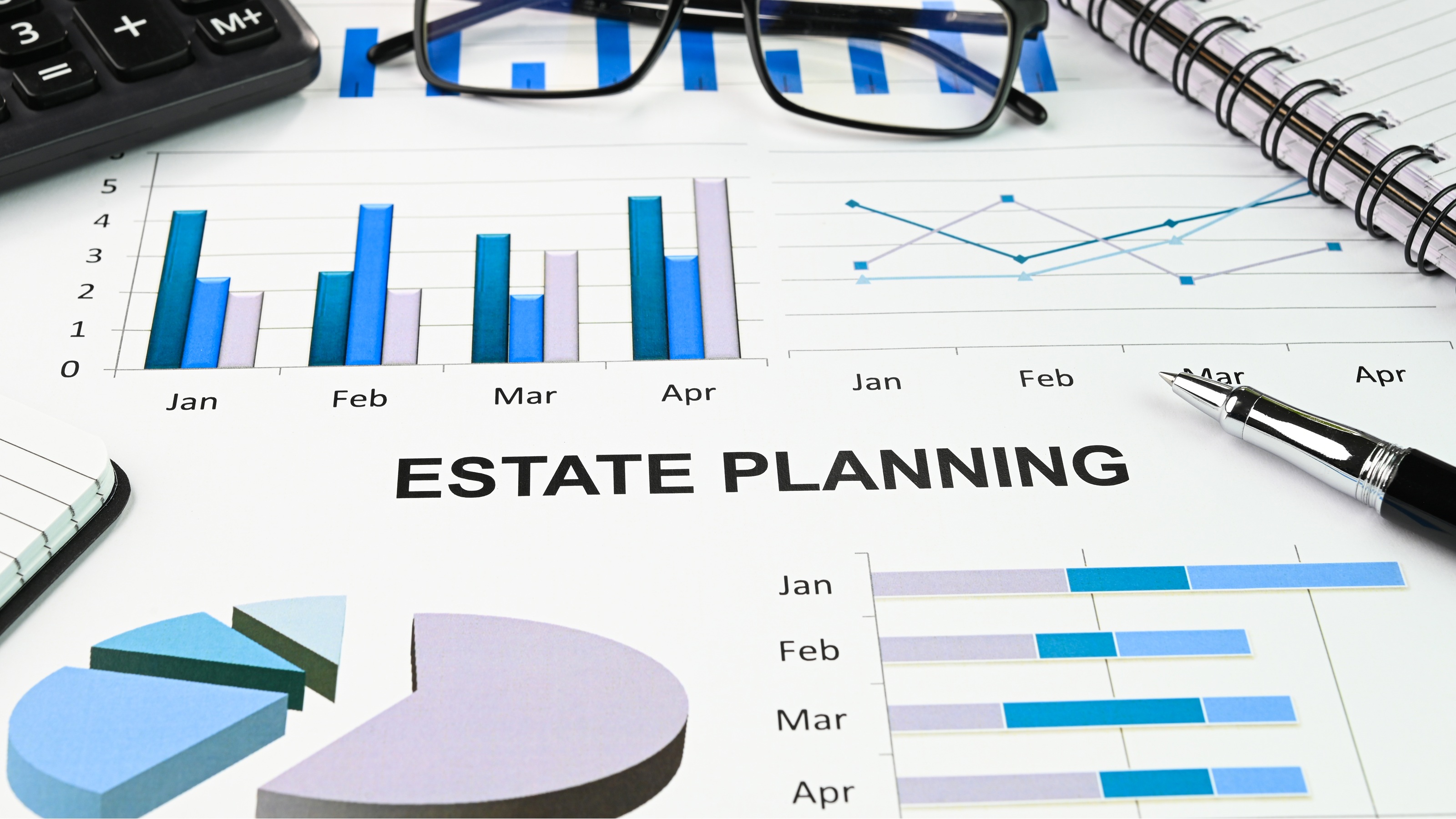 Estate planning documents with a pen, calculator and eyeglasses.