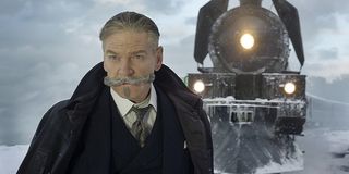 Hercule Poirot stands in front of the train in Murder on the Orient Express.
