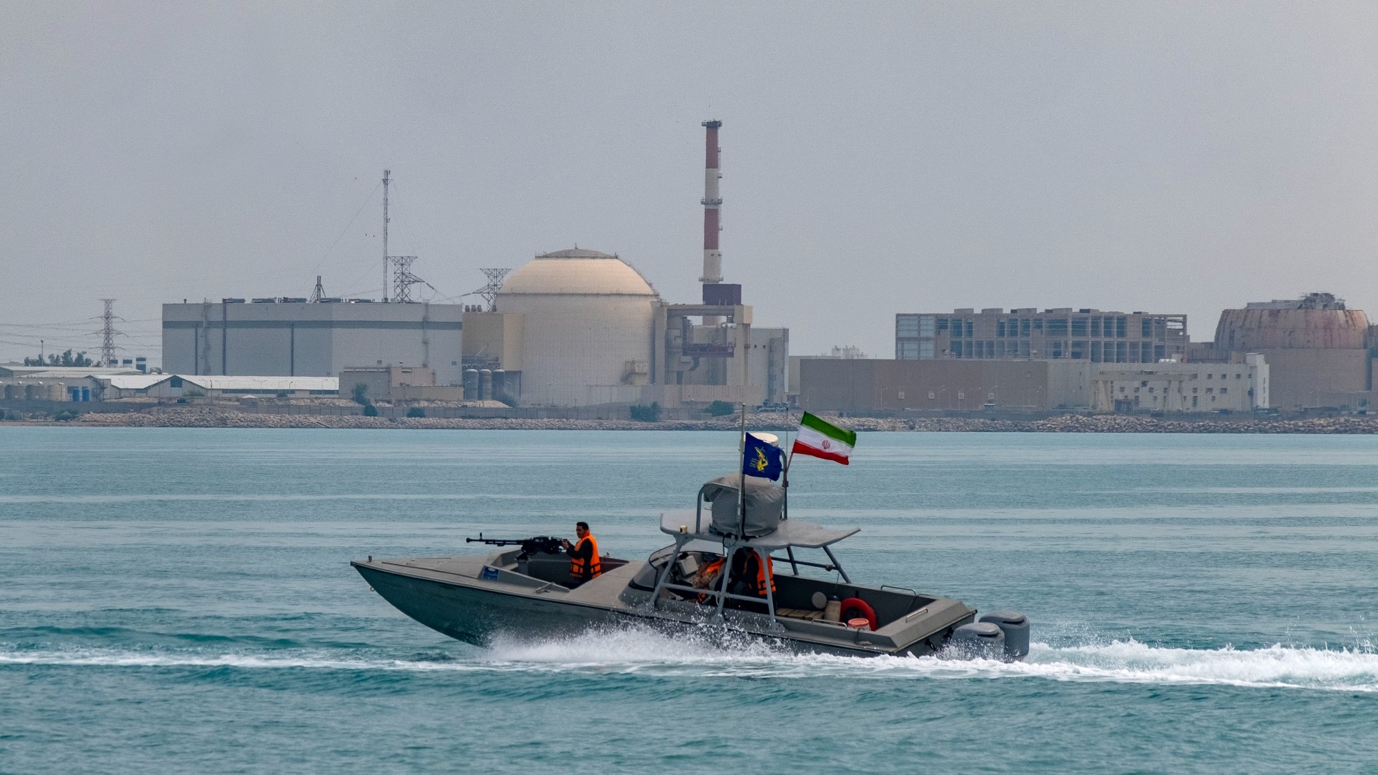 An Islamic Revolutionary Guard Corps speed boat passes the Bushehr nuclear power plant in the Iranian port city of Bushehr
