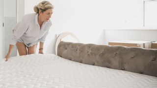 A woman moves a mattress by herself