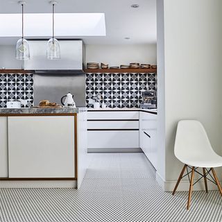 white kitchen with black and white floor tiles and splashback