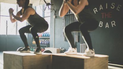 Two women squat jumping