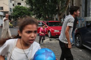 A girl looking concerned runs down the street