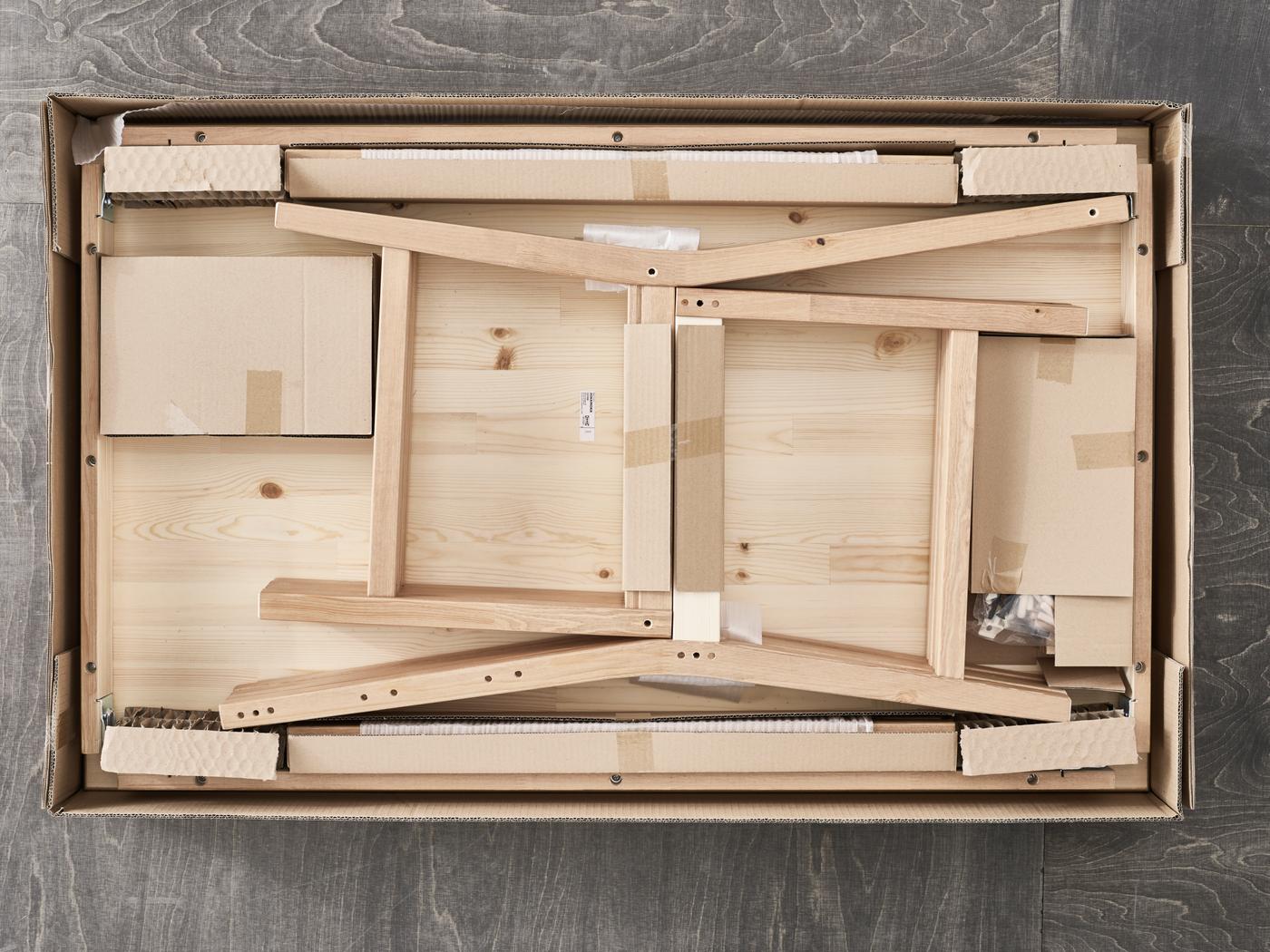 opened flatpack showing a unmounted chair and table in pine