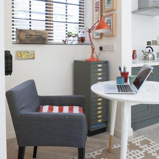 home office with white table and orange table lamp