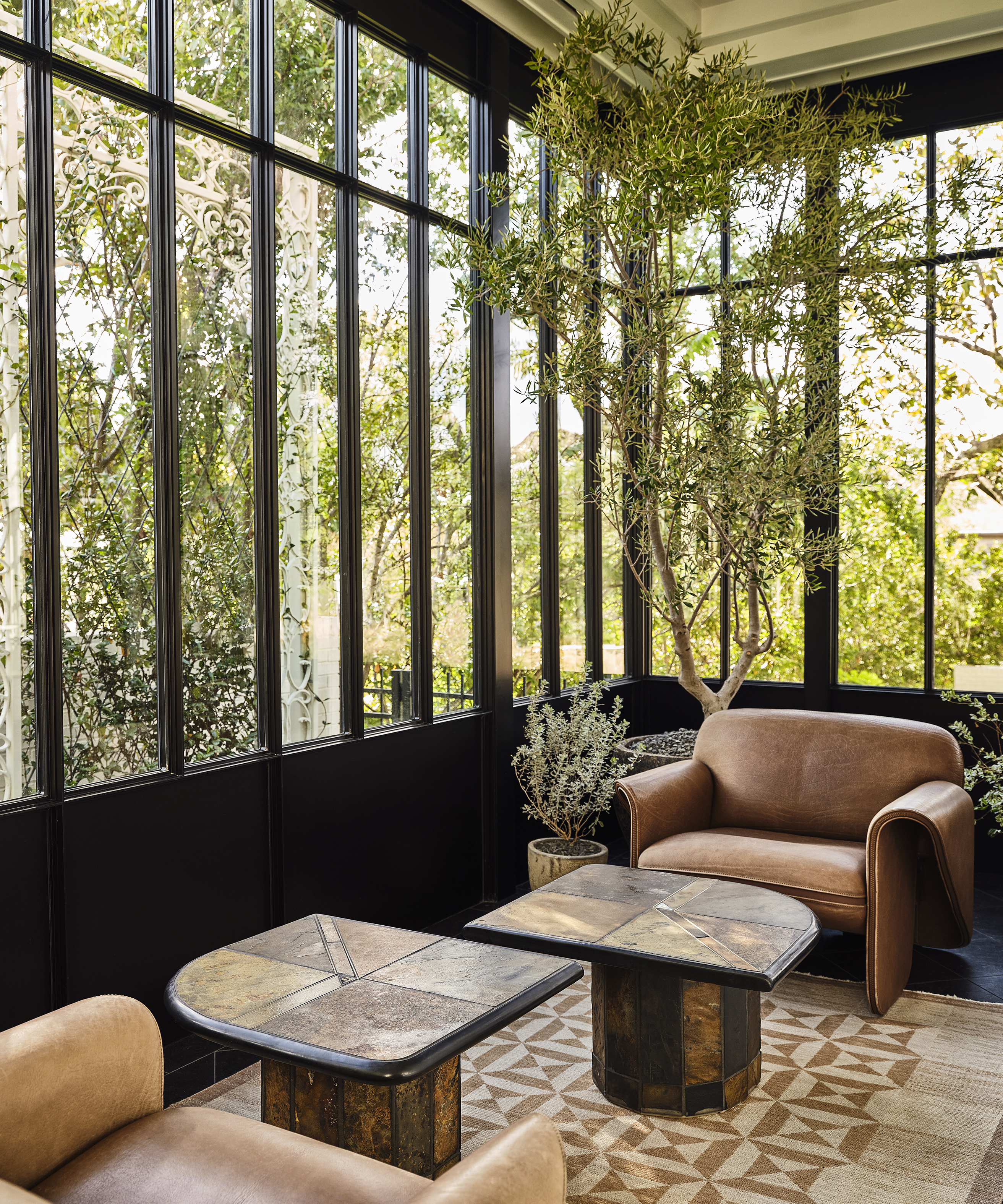 sun room with vintage coffee tables and modern arm chairs