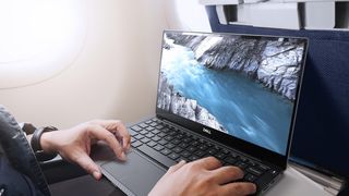 El Dell XPS en color negro, siendo usado por alguien en un avión.