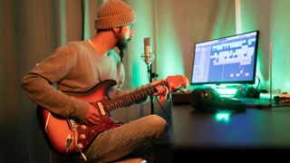 Man in the studio recording his electric guitar