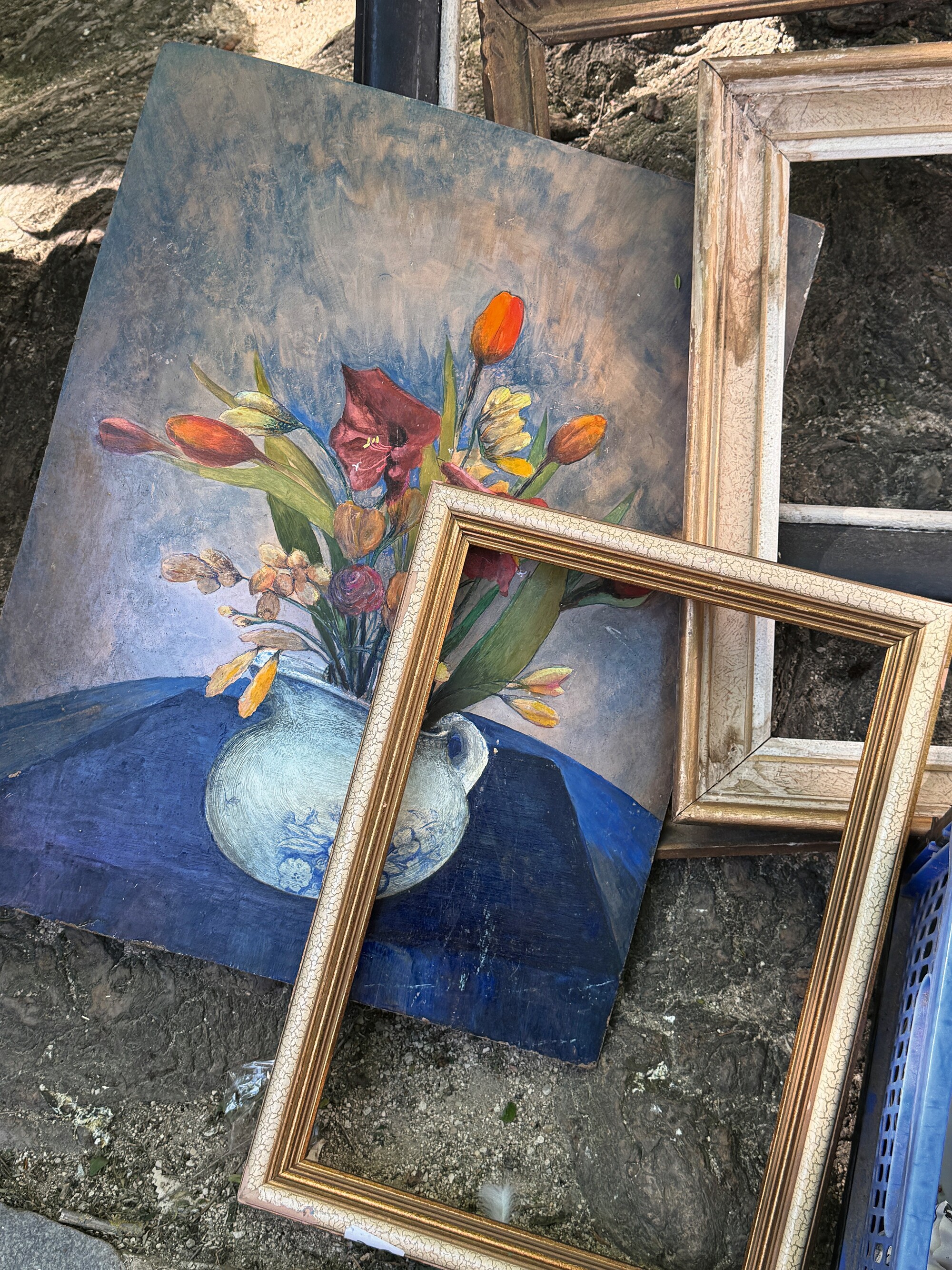 antique artwork on the side of the road next to gilded frames