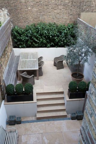 narrow modern courtyard with steps and outdoor kitchen