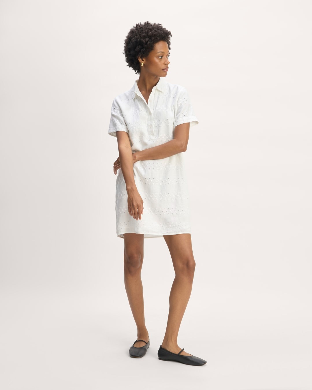 a model wears a short collared shirtdress in white