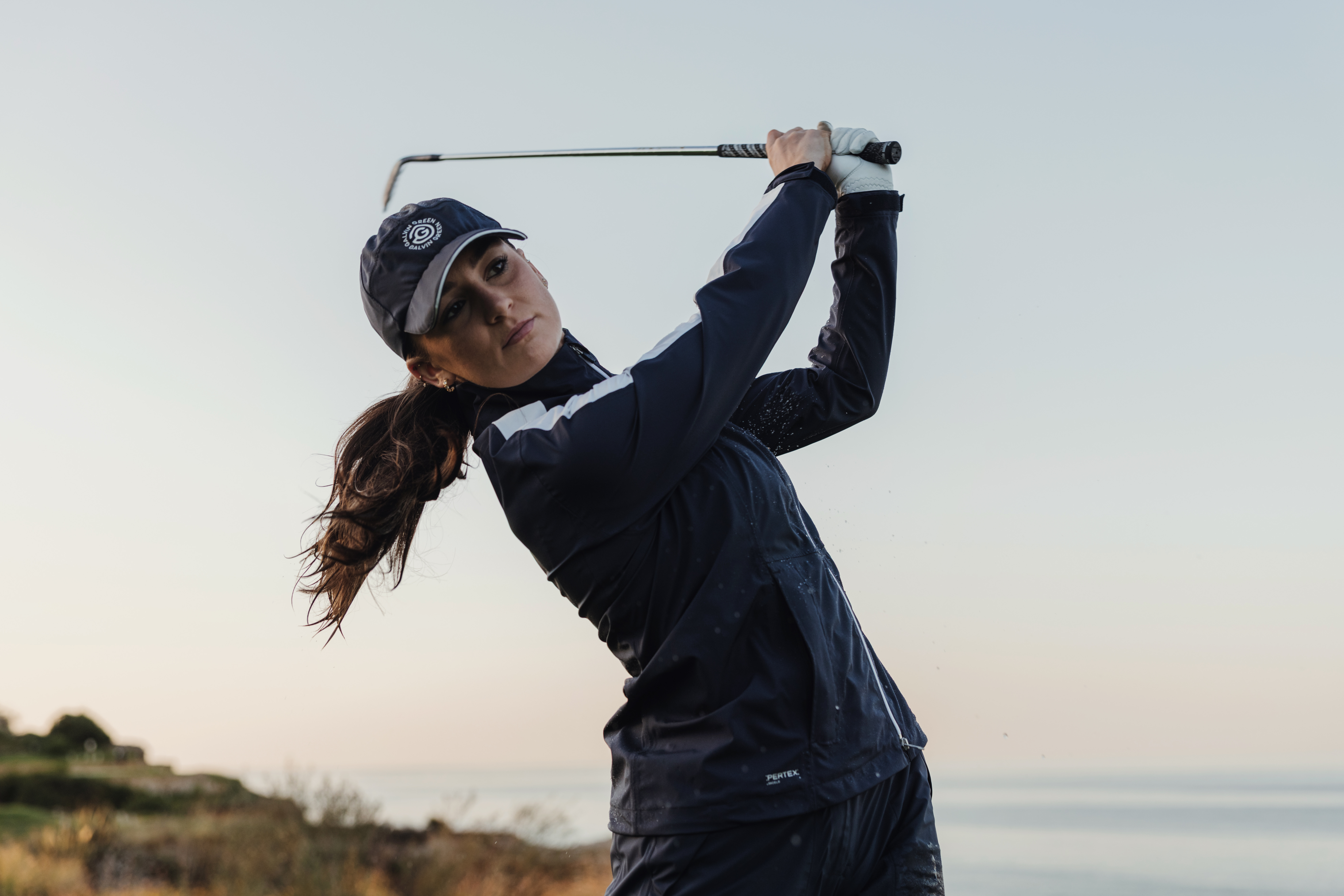 A female golfer holds their finish on an iron shot