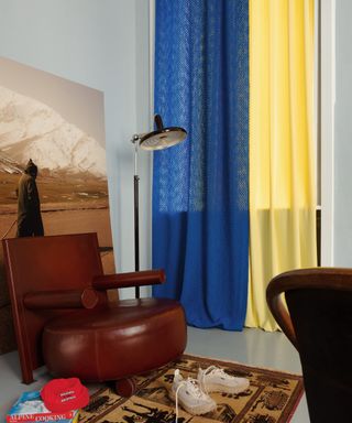 drapes vs curtains, modern retro living room with leather chair, rug, sneakers, oversized photo, floor lamp, yellow and blue drapes