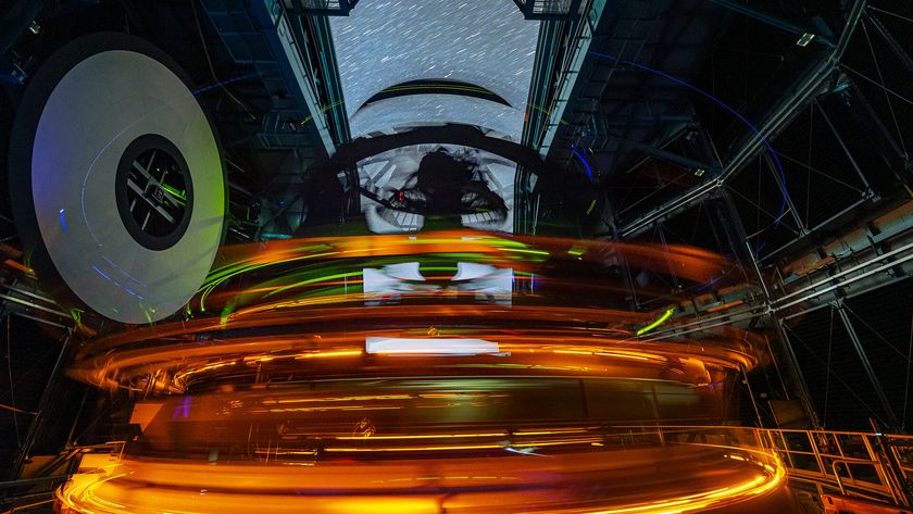 A long exposure image shows rings of glowing lights inside the dome of an observatory with streaks through the open dome showing the stars