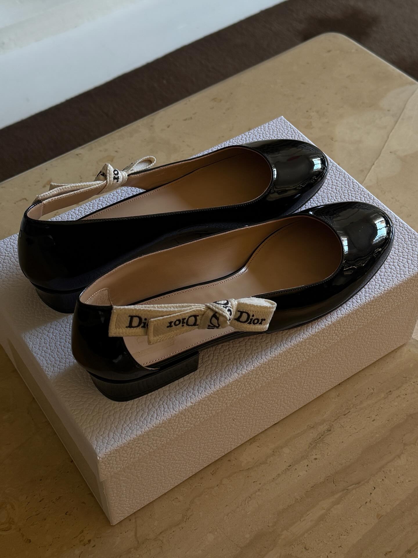 Photos of Christie Tyler wearing the new Jonathan Anderson for Dior J'Adior patent leather ballet flats from the spring/summer 2026 collection.