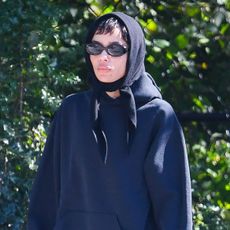 Zoë Kravitz wearing a navy sweatshirt, brown corduroy pants, and black Vans sneakers in NYC