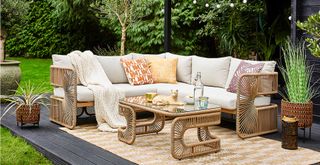 garden deck with woven outdoor sofa and coffee table
