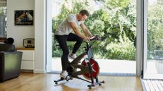 Man rides exercise bike at home