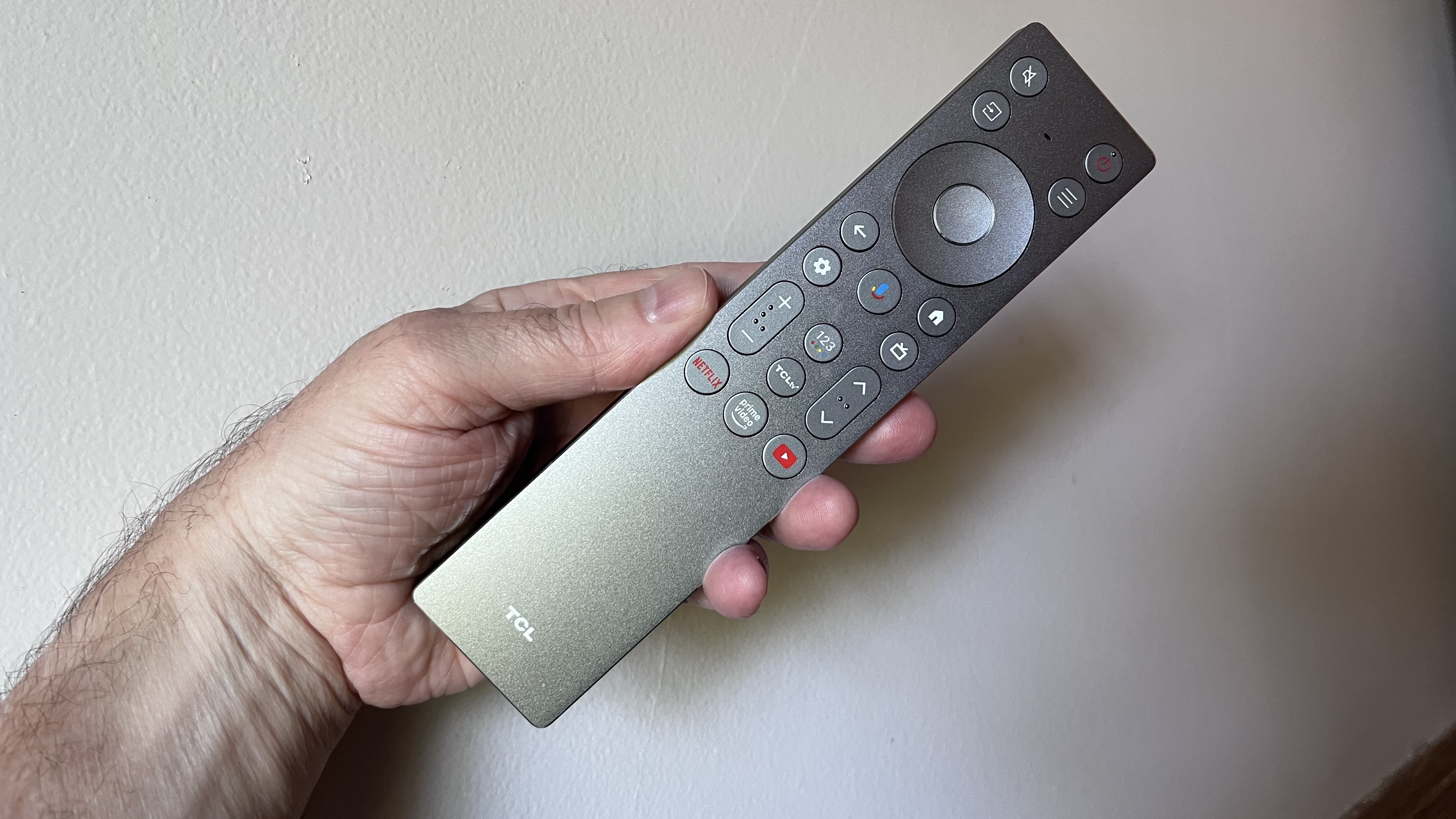 TCL QM8K remote control held in hand