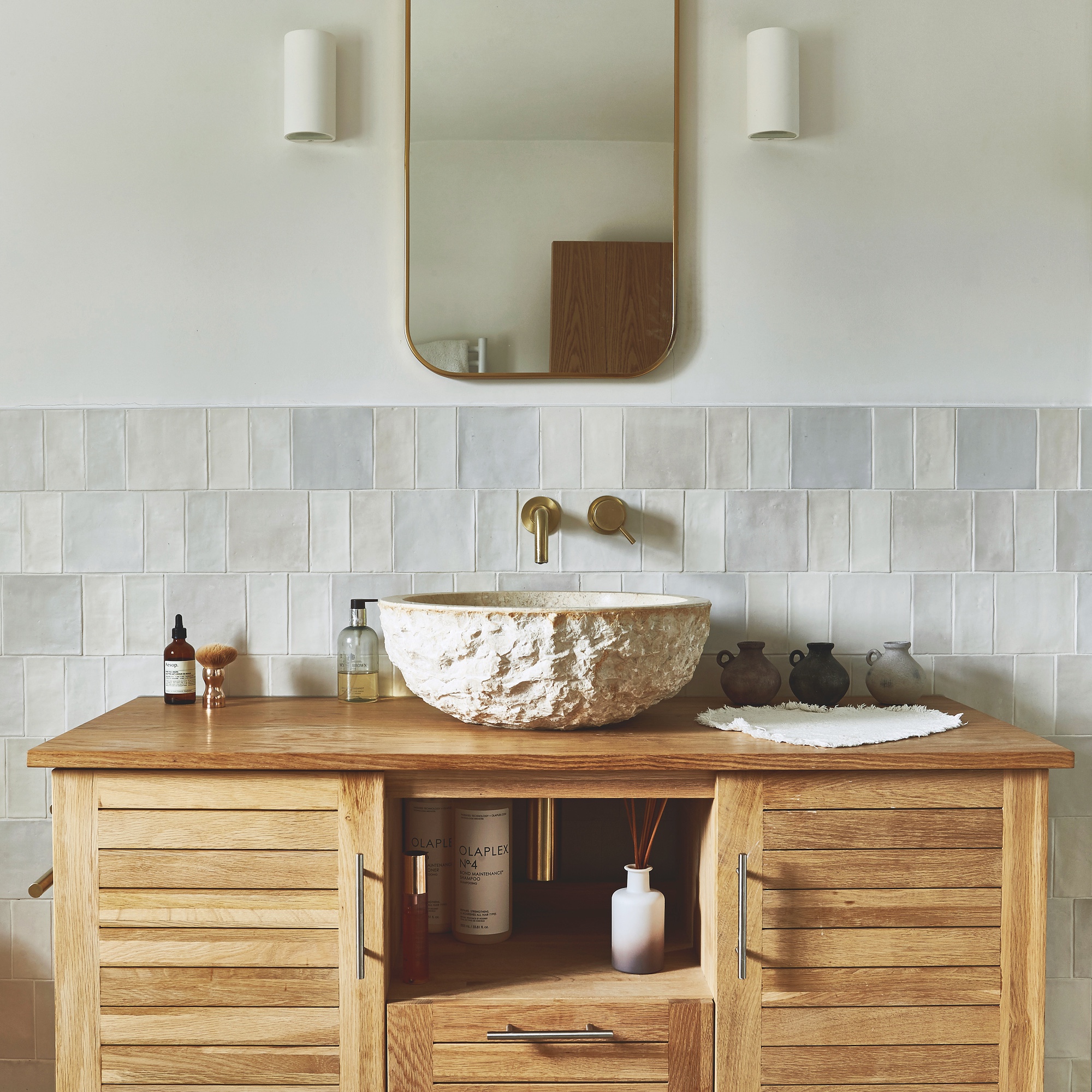 bathroom with wooden vanity unit with textured bathroom basin and wallmounted tap