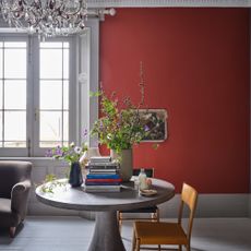 Farrow & Ball Bamboozle No.304 in a large living room with a wide window, and a middle table with flowers and books on it