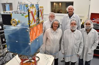 Celestis and Surrey Satellite Technology staff next to the orbital test bed after completing Flight Capsule Payload Integration I.